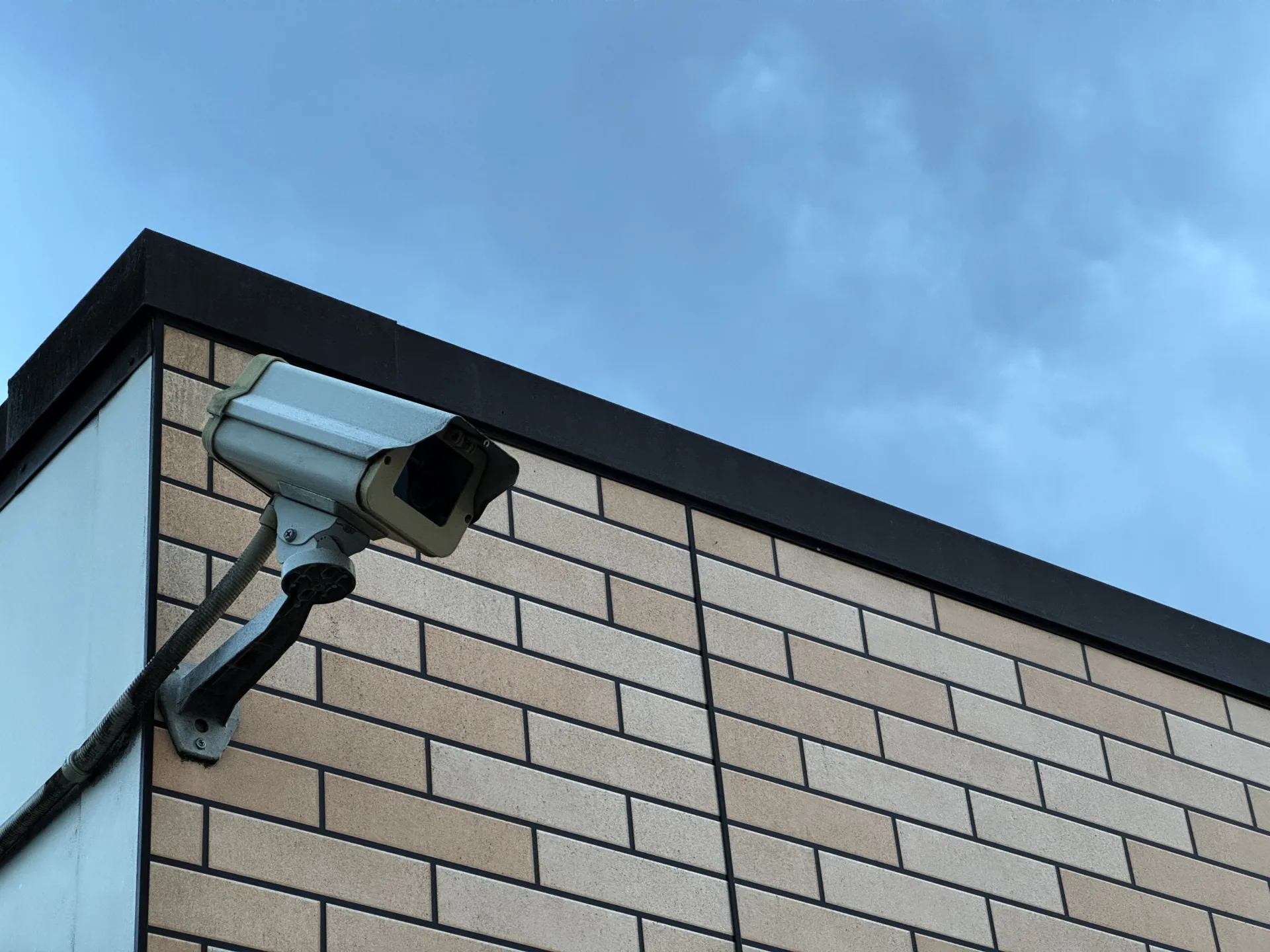 建物の外壁角に設置された屋外用ボックス型防犯カメラ