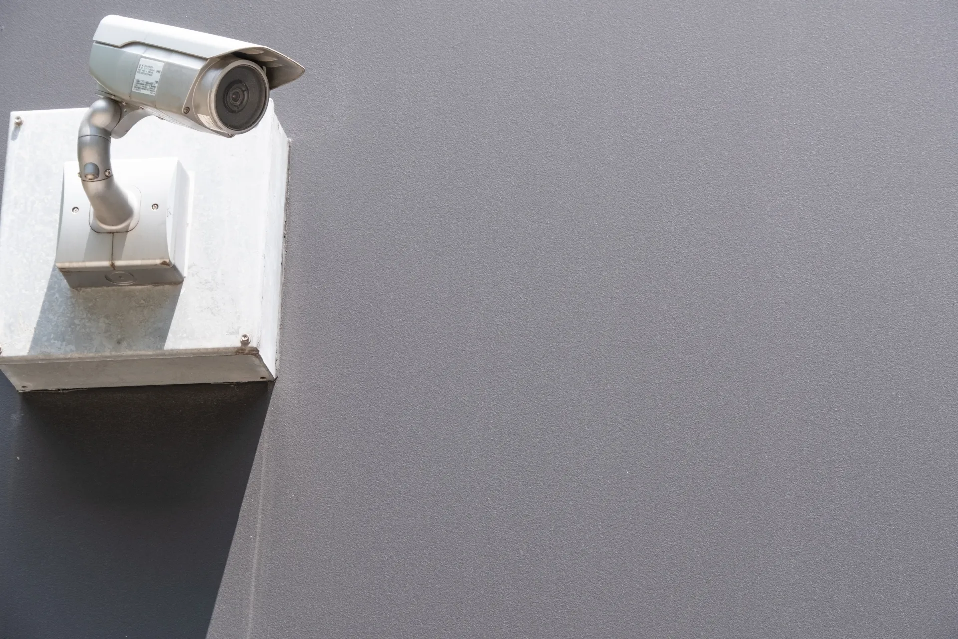 外壁のボックス上部に取り付けられた屋外用バレット型防犯カメラ