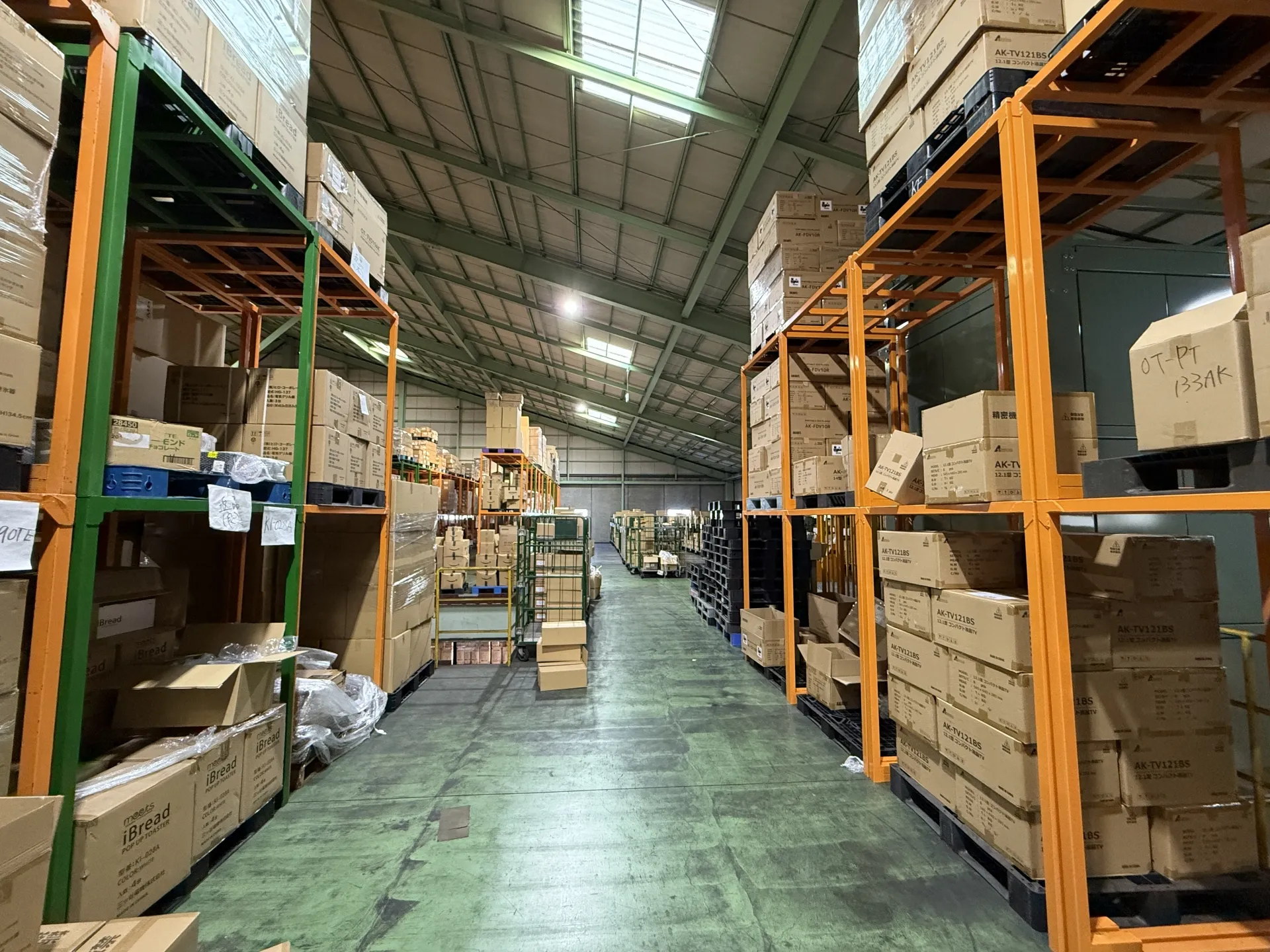 棚と段ボールが並ぶ倉庫内通路の様子