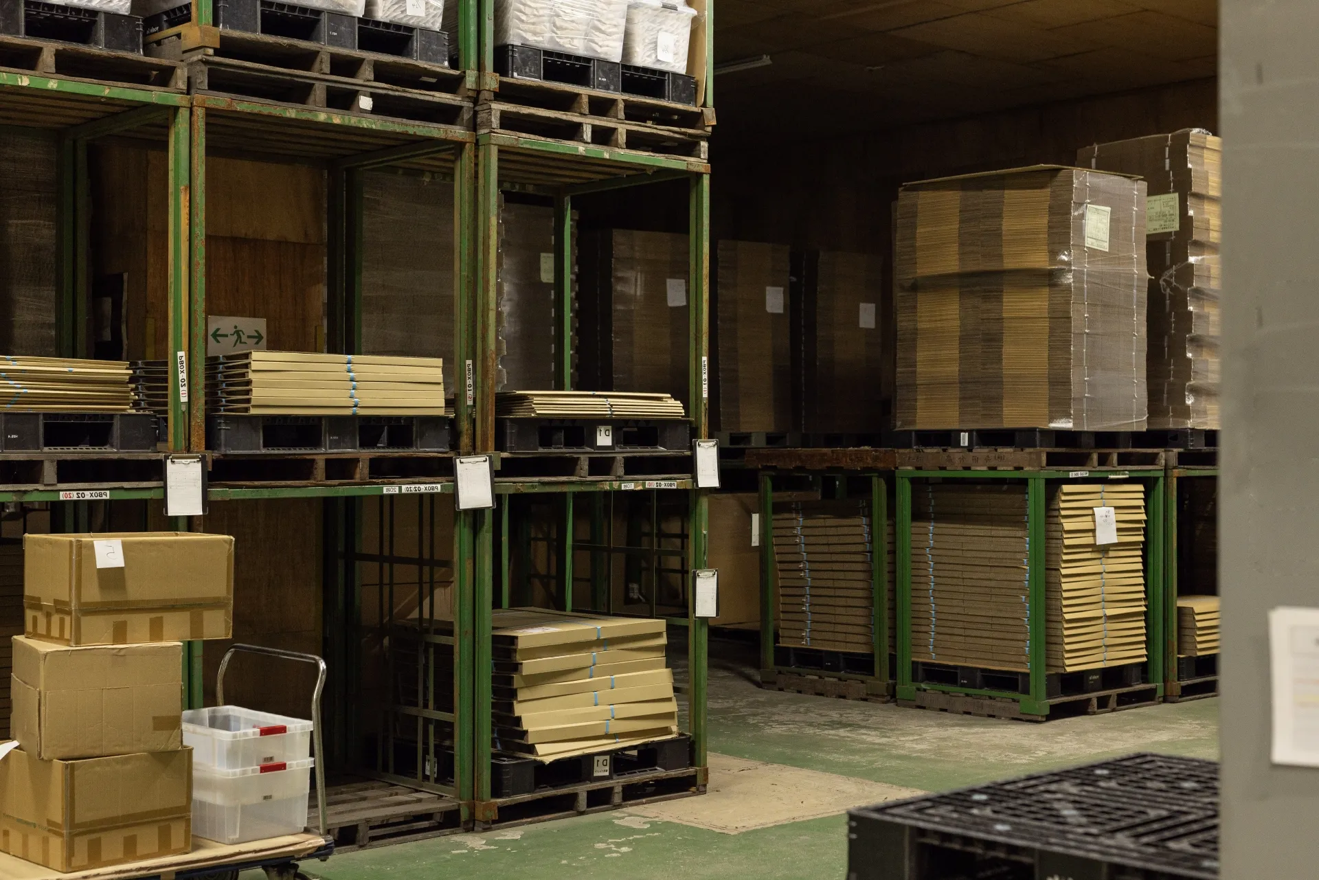 ラックに資材や段ボールを保管している倉庫内の様子