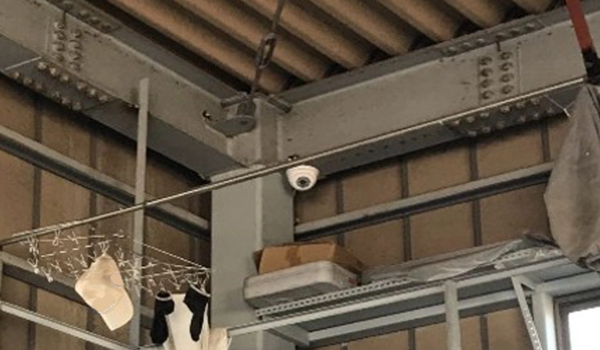 倉庫内の高所棚上部を見下ろす位置に設置された屋内用ドーム型防犯カメラ